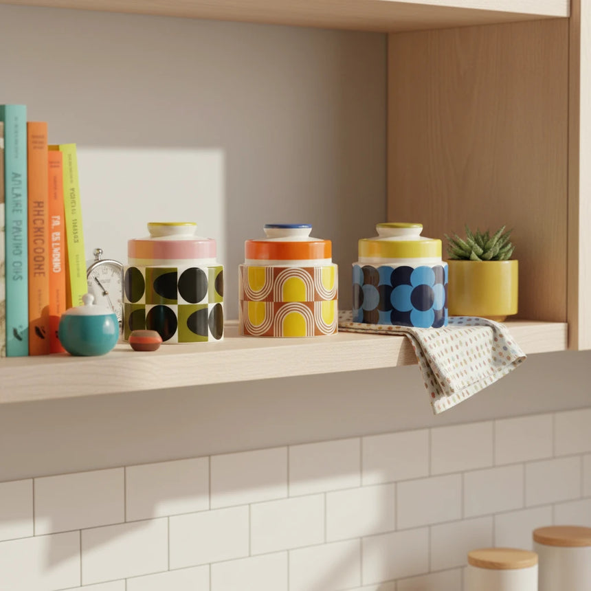 Three ceramic jars with colorful geometric patterns on a beige background