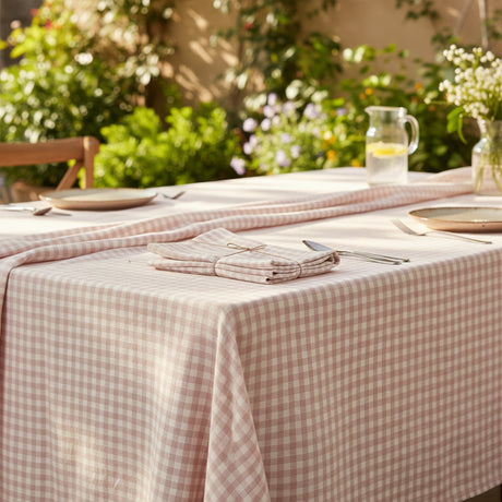 Folded checkered tablecloth  with a pink and white pattern on a white background