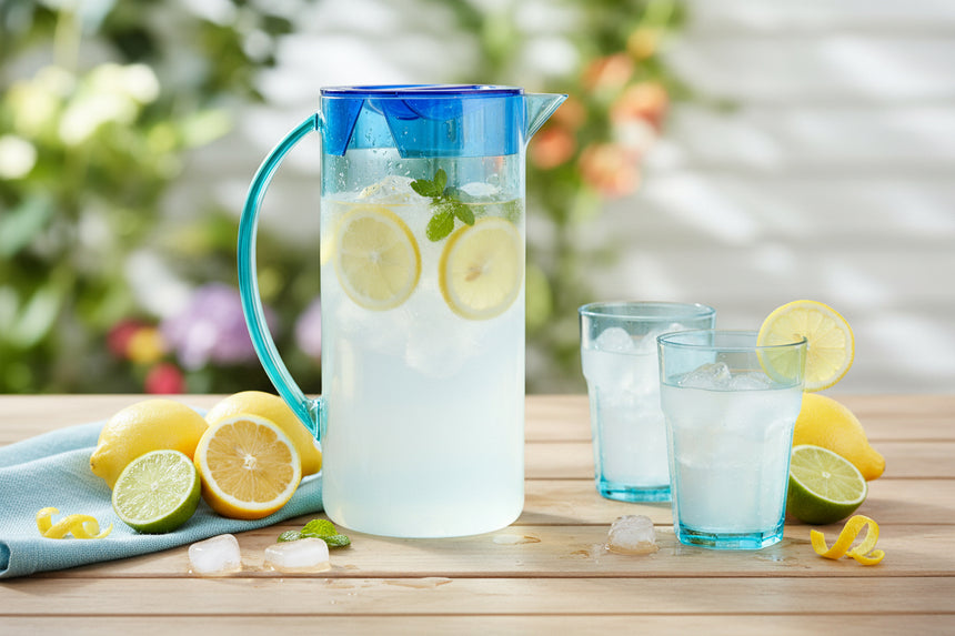 Clear pitcher with blue lid on a white background