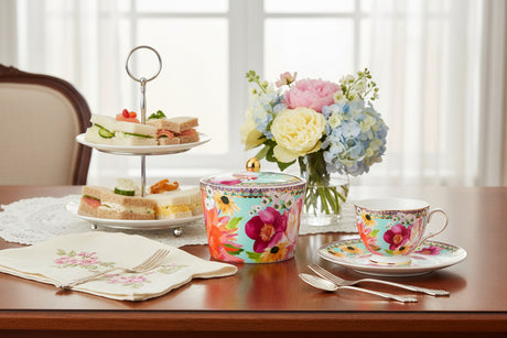 Colorful floral-patterned  sugar bowl with a gold knob lid on a white background