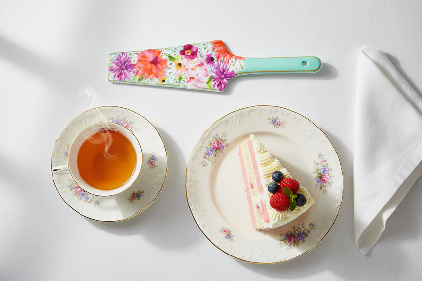 Floral-patterned cake server with a light blue handle on a white background