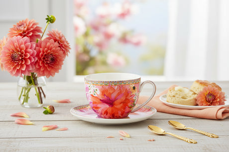 Colorful floral teacup and saucer on a white background