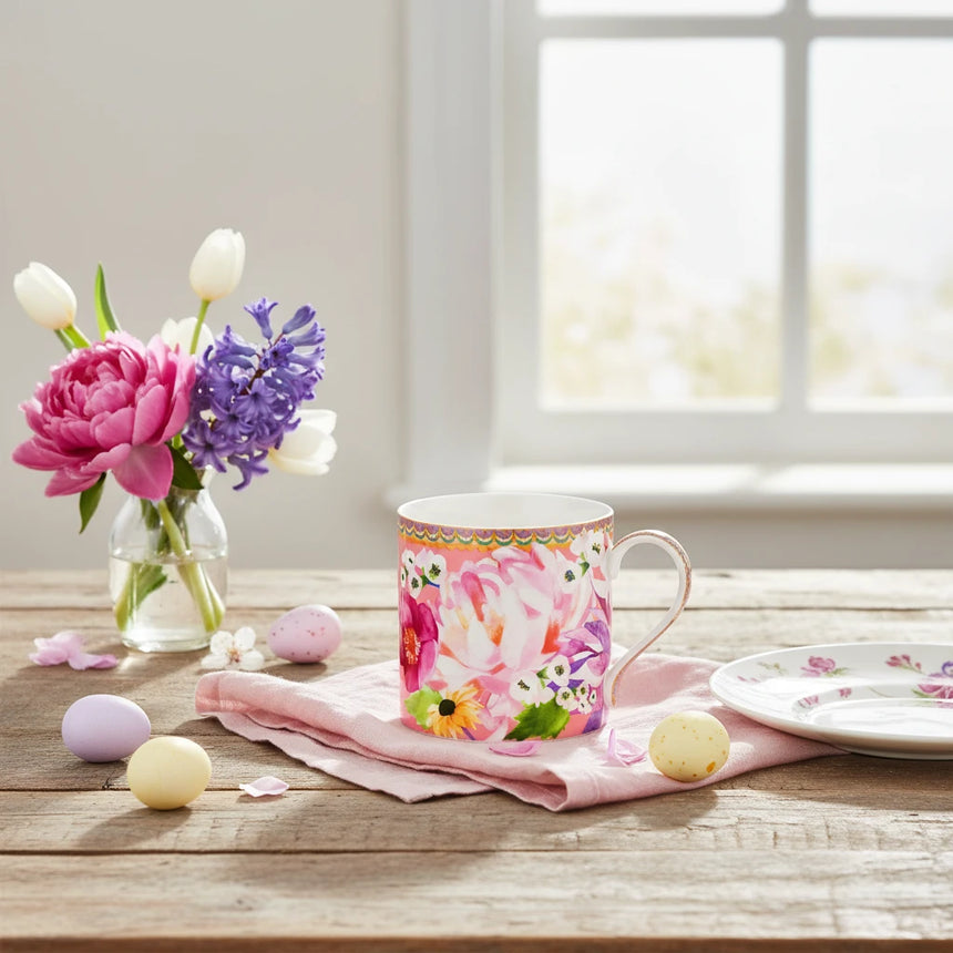 Colorful floral mug with a decorative handle on a white background