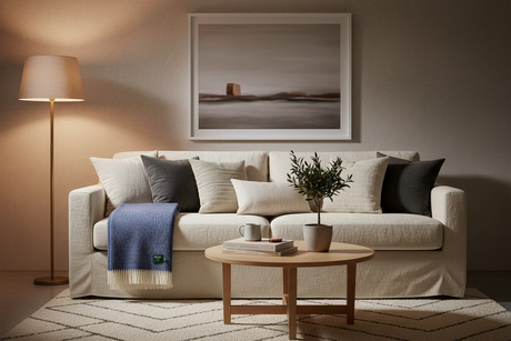 A folded blue and cream woven throw blanket with fringe, featuring a small green Bronte label on the lower right, set against a plain light gray background.