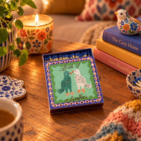 Matchbox with illustration of two birds and 'Birds of a feather' text on a white background