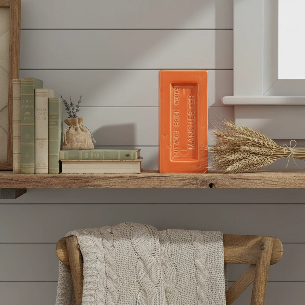 Orange brick-shaped vase with 'Outwood Brick Works Manchester' text on a white background