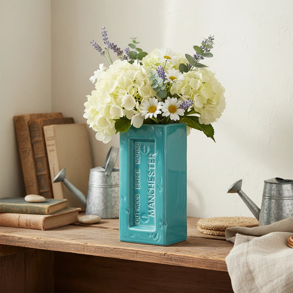 Teal rectangular vase with 'Outwood Brick Works Manchester' branding on a white background