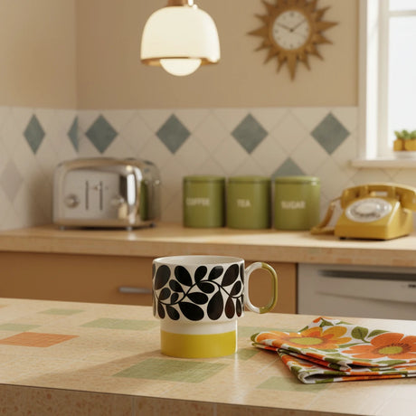 Mug with black leaf pattern and yellow base on a beige background