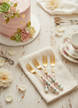 Four gold forks with patterned handles on a white background