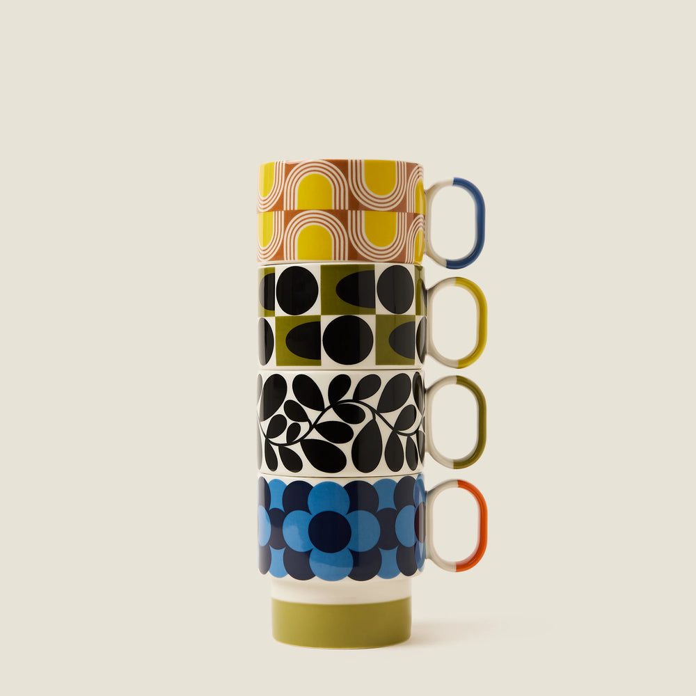 Stack of colorful patterned mugs on a beige background