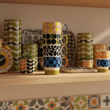 Stack of colorful patterned mugs on a beige background