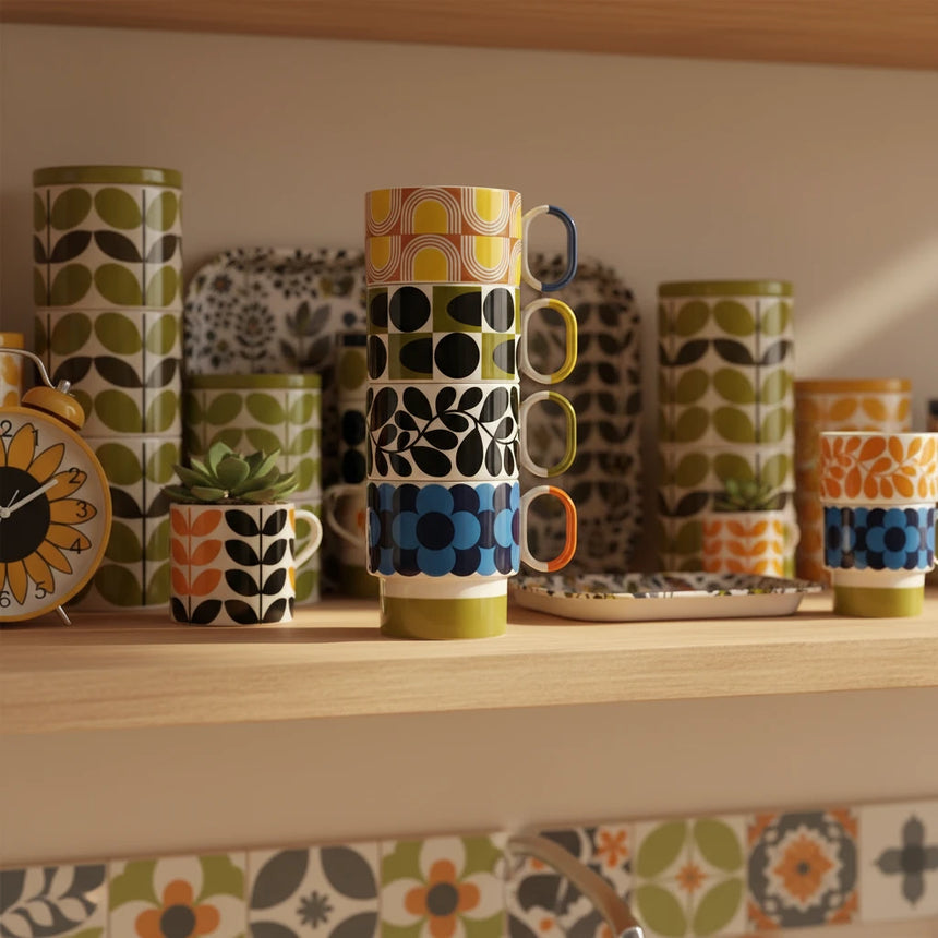 Stack of colorful patterned mugs on a beige background
