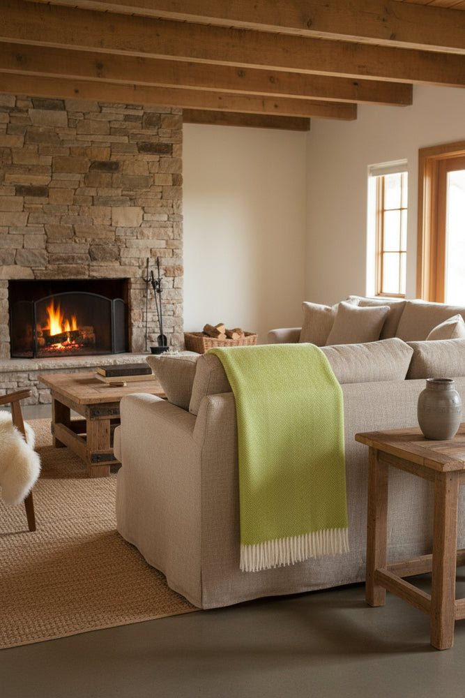 A lime green Bronte By Moon herringbone Shetland wool throw with tassels on the ends, laid flat on a white background.