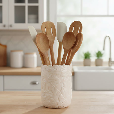 An off-white ceramic utensil holder  with a textured, embossed leaf pattern and a scalloped rim, shown on a plain white background.