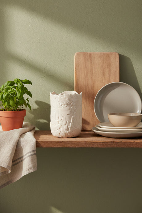An off-white ceramic utensils holder with a textured, embossed leaf pattern and a scalloped rim, shown on a plain white background.