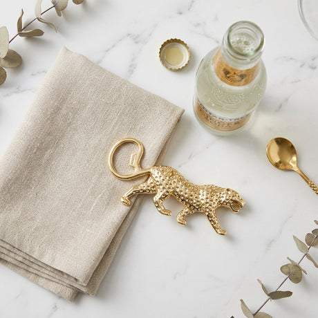 A gold leopard-shaped bottle opener  with a textured surface , shown on a plain white background.