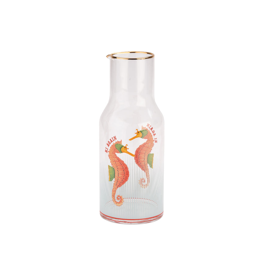 glass carafe with seahorse design on a white background