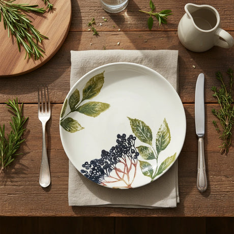 Round ceramic dish with leaf and berry design on a white background
