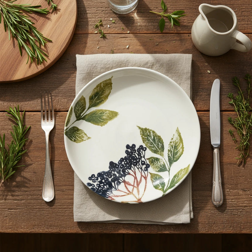 Round ceramic dish with leaf and berry design on a white background