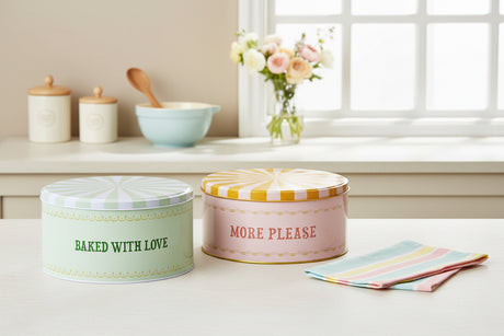 Two round storage tins with decorative lids on a white background