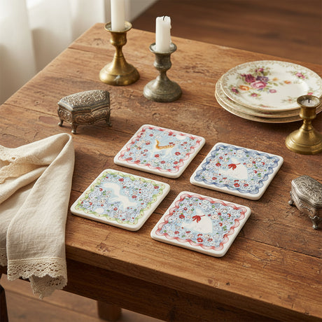 Set of four coasters  with floral and animal designs on a white background
