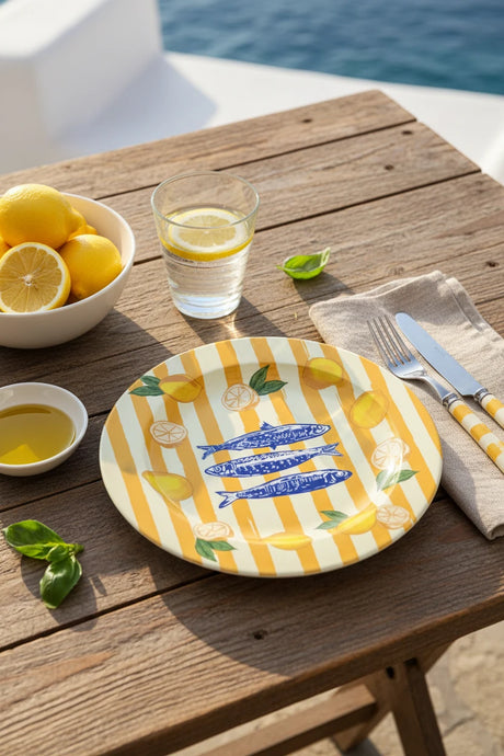 Decorative plate with blue fish, lemons, and yellow stripes on a white background