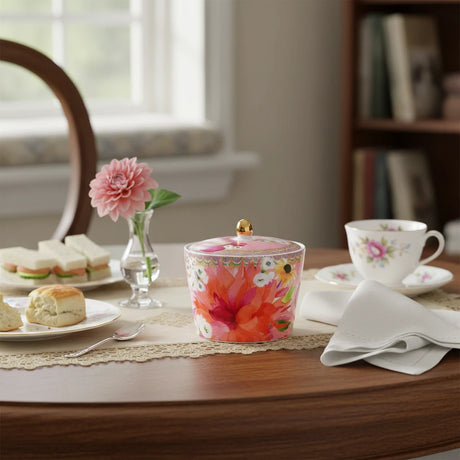 Sugar bowl with floral design and gold knob lid on a white background