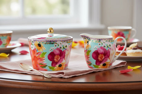 Colorful floral-patterned sugar bowl  with a gold knob lid on a white background