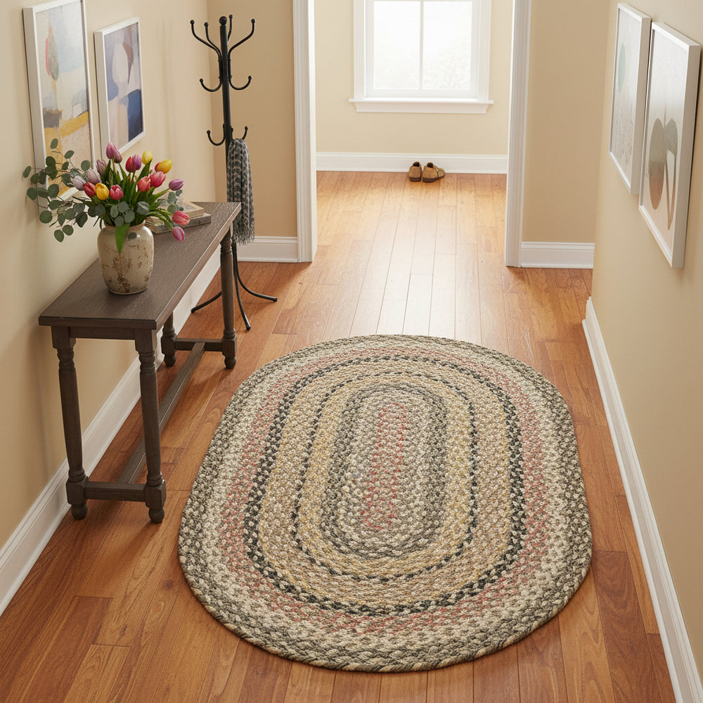 Oval braided rug with multicolor pattern on a white background