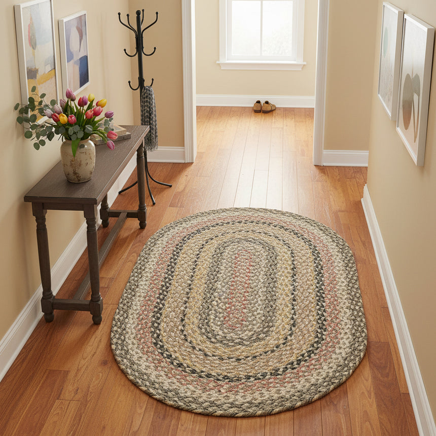Oval braided rug with multicolor pattern on a white background