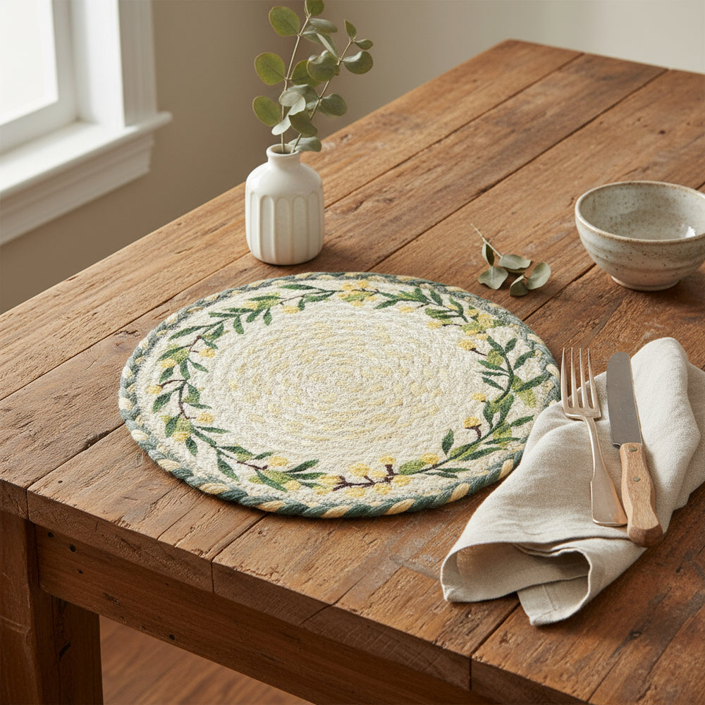 Round woven placemat with green leaf and yellow lemons design on a white background