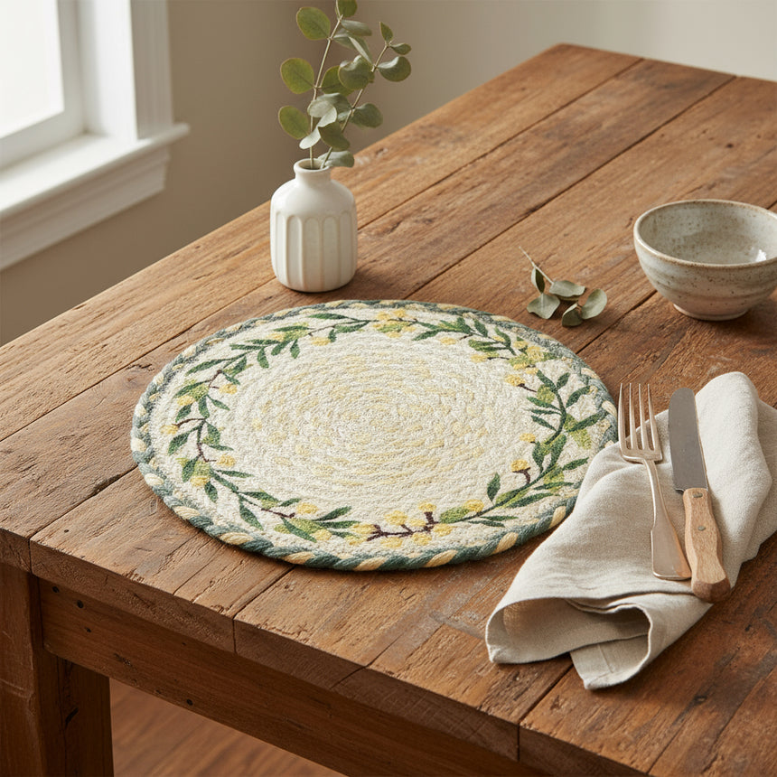Round woven placemat with green leaf and yellow lemons design on a white background